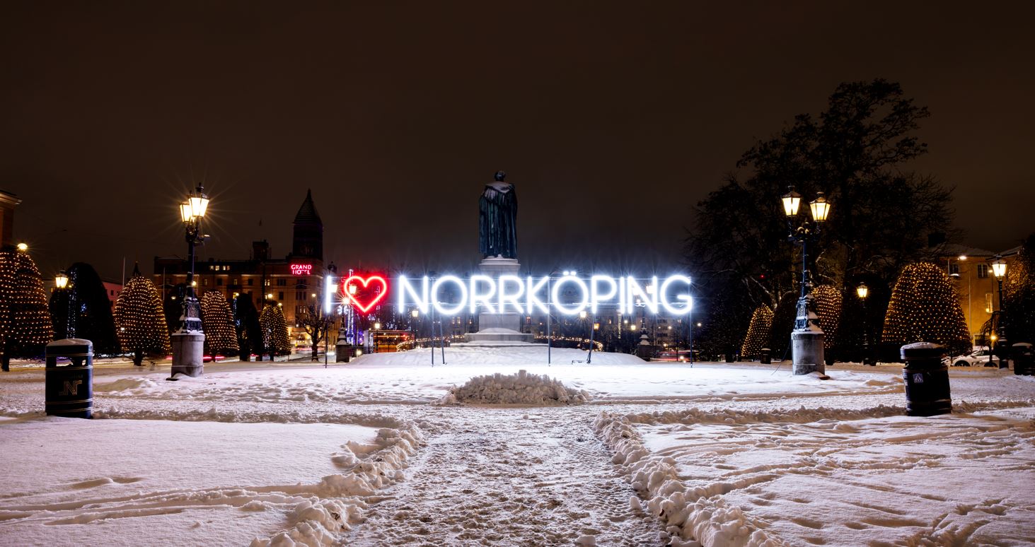 Text i, ett hjärta och text Norrköping lysande, vit snö under.